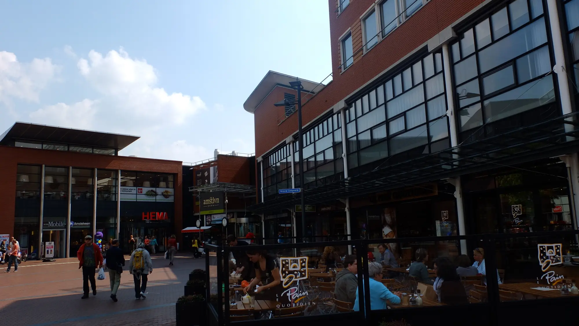 Winkelend publiek op een terras en bij de winkels in het Stadshart van Amstelveen